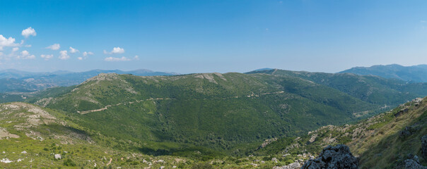 Panoramic view from white limestone tower Perda Liana, impressive rock boulders, green forest hill and mountain. National Park of Barbagia, Central Sardinia, Italy, summer day.