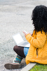 Obraz premium young woman in the city with her cell phone and laptop