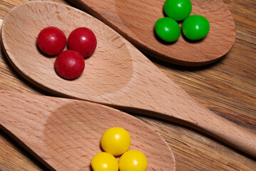 Three wood spoons with colorful candies