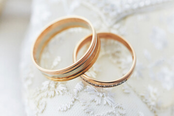 Obraz na płótnie Canvas golden wedding rings on a white lace background. wedding ceremon