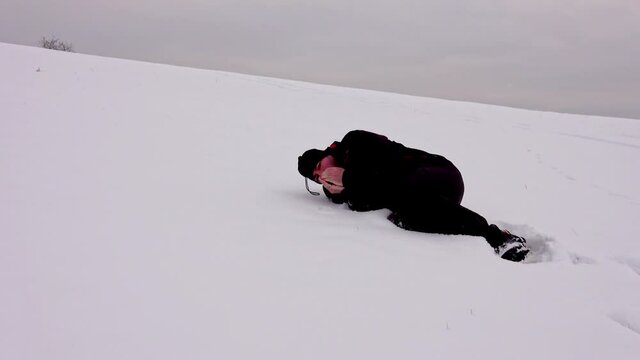 Hiker, tired, alone, fallen in the snow, trembling. Hypothermia