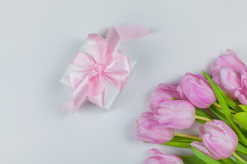Gift box with ribbon, bouquet of pink tulips on a white background. Mothers Day. International Women's Day. Holidays.