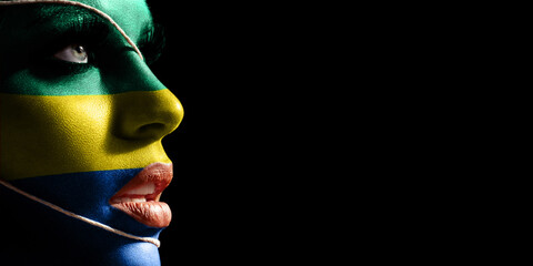 Gabon flag painted on a face of a young woman, national flag