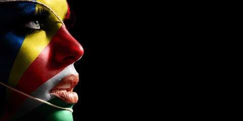 Seychelles flag painted on a face of a young woman, national flag