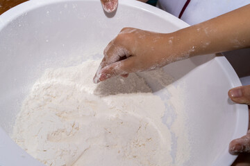 A boy is make bun for pizza.