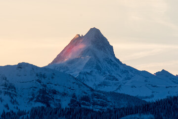 Fototapeta na wymiar peak of Schreckhorn at dawn with red clouds in winter