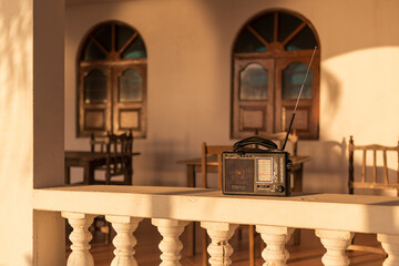 A small radio outside a house in the evening light