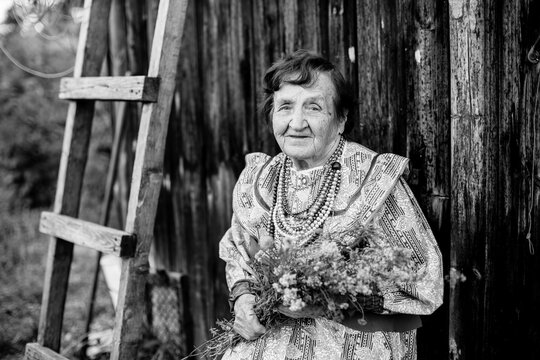 Portrait of old woman in the russian village. Black and white photo.