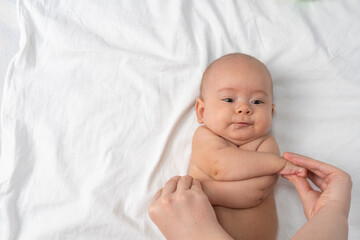 Children's massage. Mother doing gymnastics to the newborn.