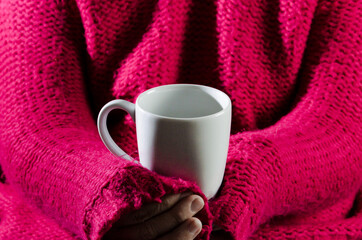 Adult woman with red sweater holding a cup of latte coffee