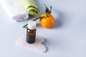 Ripe Tangerines and Small Bottle of Essential Citrus Oil Blue Background Spa Concept Copy Space