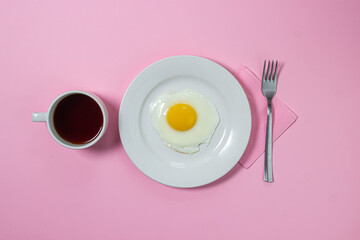 Scrambled eggs on a pink background. Fried eggs on a white plate. Delicious breakfast with a cup of coffee.