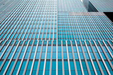 Symmetrical blue windows reflecting the sky on a skyscraper