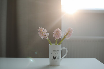 Spring flowers in cup on a table. Cozy home decor