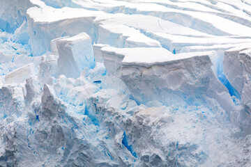 Ice sculptured at the glaciers edge, with the deep blue of the crevasses contrasting with the white of the younger ice layers.