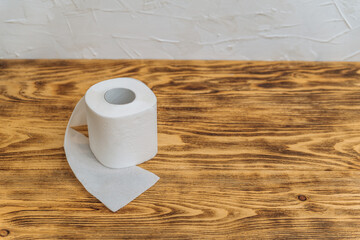 roll of white toilet paper on wooden background copy space