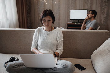 Busy man and woman studying hard with laptop on deadline in living room at home