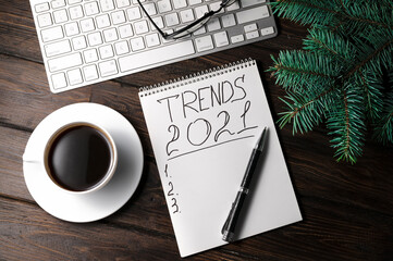 Top view of notepad with trends List, cup of coffee on wooden table