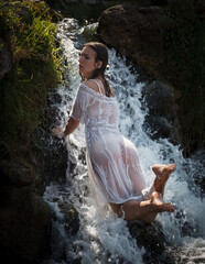 Seminude woman in a waterfall - obrazy, fototapety, plakaty