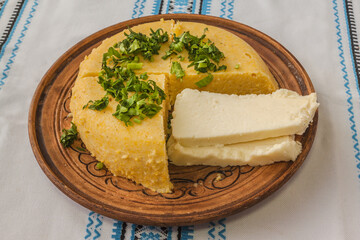 Hominy or mamalyga with chopped feta cheese and  parsley on a plate
