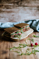 Food still life, fresh whole grain bread with cheese, radish, cucumber, arugula, healthy food, superfood