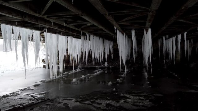 lots of hanging icicles under the bridge