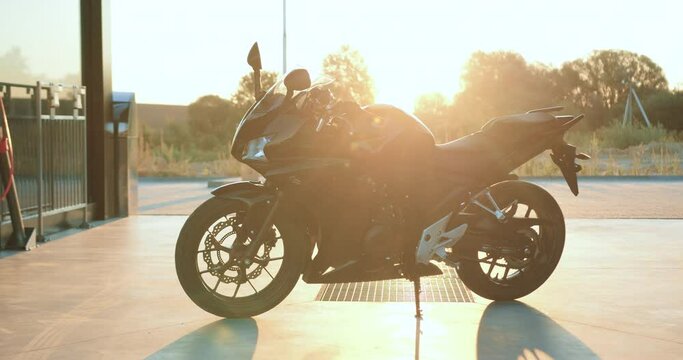 Attractive picture of modern expensive motorbike which standing under sunshines on concrete square