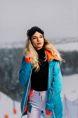 Happy girl snowboarder posing in sunglasses with snowboard