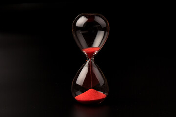 Crystal hourglass on black background as a concept of passing time for business term, urgency and...