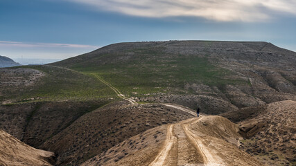 Photographer traveler on a dirt road in mountains