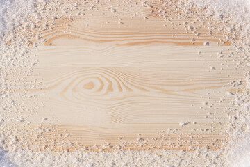 Wooden table with fluffy snow around. Winter background.