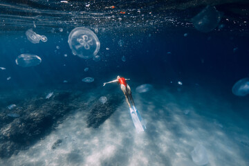 Female free diver swim with jellyfish in blue ocean. Jellyfish in blue sea and freediver girl © artifirsov