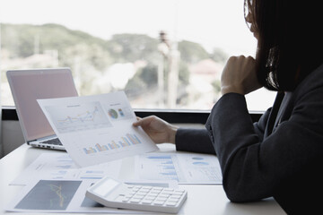 Financial businesswomen analyze the graph of the company's performance to create profits and growth, Market research reports and income statistics, Financial and Accounting concept.