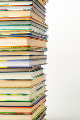 A stack of multi-colored books on a white background with space for writing text.