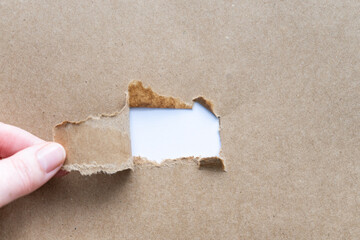 Hand reisst braunes Papier auf mit einem leeren weißen Hintergrund. Botschaft, Draufsicht....