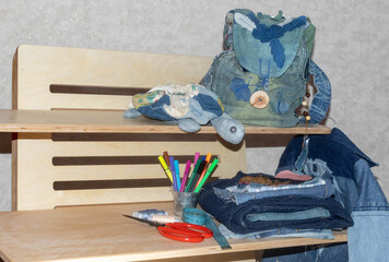 New things made from old jeans: toy turtle, backpack, jacket and patterns. Denim ready to upcycling and tailoring accessories. Concept of things reuse and natural resources preserving.