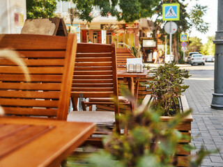 Fototapeta na wymiar Wooden furniture on the summer veranda in the cafe. Sunny day