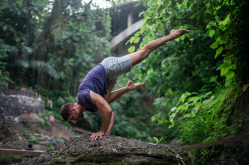 Naklejka na ściany i meble Man practice Yoga outdoor. Practice and meditation in jungle.