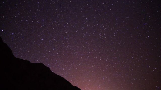 Stars at Night Sky Time Lapse. Milky Way and Purple Nightsky Above Mountain Hill