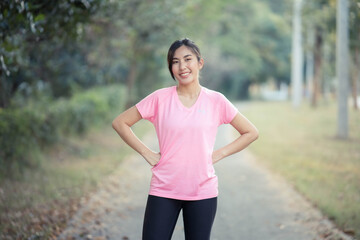 Asian girl is stretching her body warm muscles before going out for a run at the park