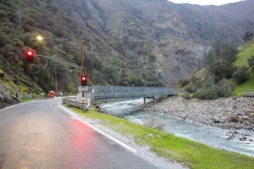 Foto op Plexiglas construction site at road with red traffic ligh in yosemite national park by bad weather with river bridge spanning Mariposa creek © travelview