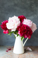 Vase with bouquet of beautiful peonies on table in room, close-up. Bloom. Peony. Postcard. 