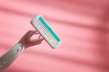 Female shaver for legs and bikini area on a pink background.