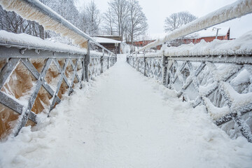 A snow-covered, icy bridge over a waterfall in the Old City in Helsinki, Finland.