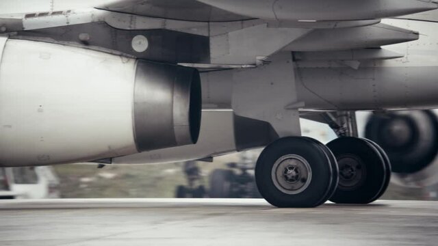 Heat shimmer behind jet engine and landing gear of taxiing airplane. The plane rolls on the runway.