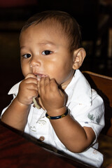 Tiny Filippino boy eating udon noodles
