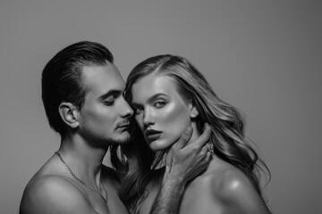 Monochrome, black and white close up studio fashion portrait of couple: beautiful confident woman and handsome strong man. 