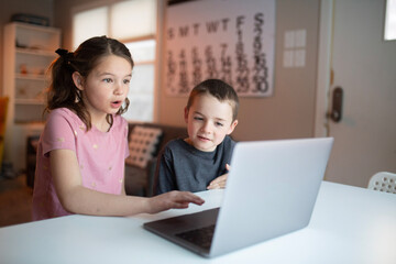 boy and girl looking at a laptop with a worried and confused look