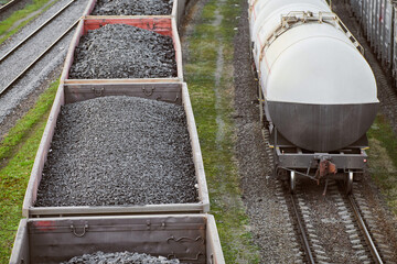 Freight train with cargo cars transporting coal, wood, fuel