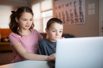 boy and girl looking at a laptop with a worried and confused look